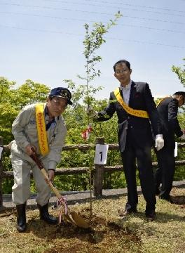 植樹する野口英一理事長(右)と忍野村の天野多喜男村長