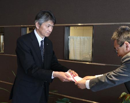 目録を手渡す樋上和人所長(左)