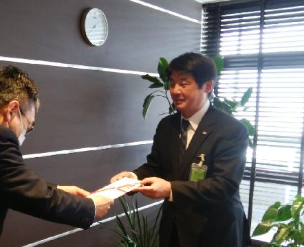 寄付金の目録を手渡す阿部直樹所長(右)
