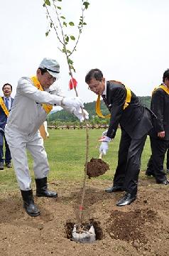 植樹をする野口理事長(右)と高村村長=山中湖花の都公園