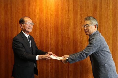 目録を手渡す渡辺喜久男大会会長(左)=甲府・山日YBS本社