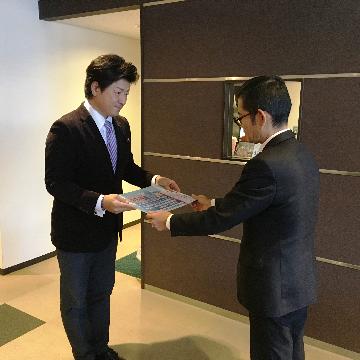 寄付金を寄贈する志村禎哉常務(左)