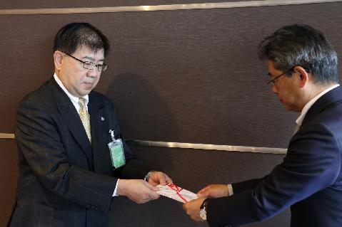 寄付金の目録を手渡す仙木伸介会長(左)