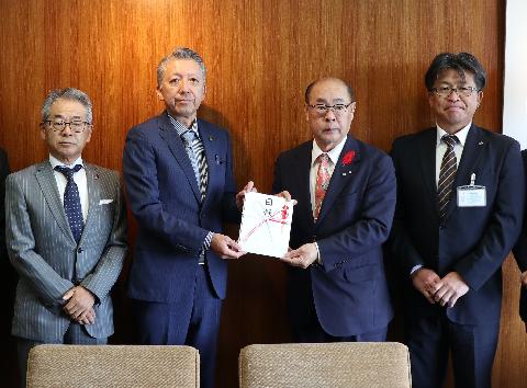 目録を手渡す渡辺英之大会会長(右から2番目)=甲府・山日YBS本社
